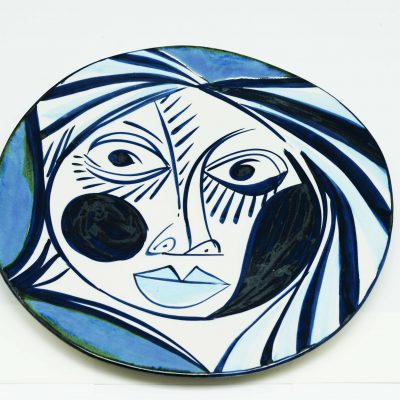 Plato cerámico llano con rostro dibujado. Colección plato azul